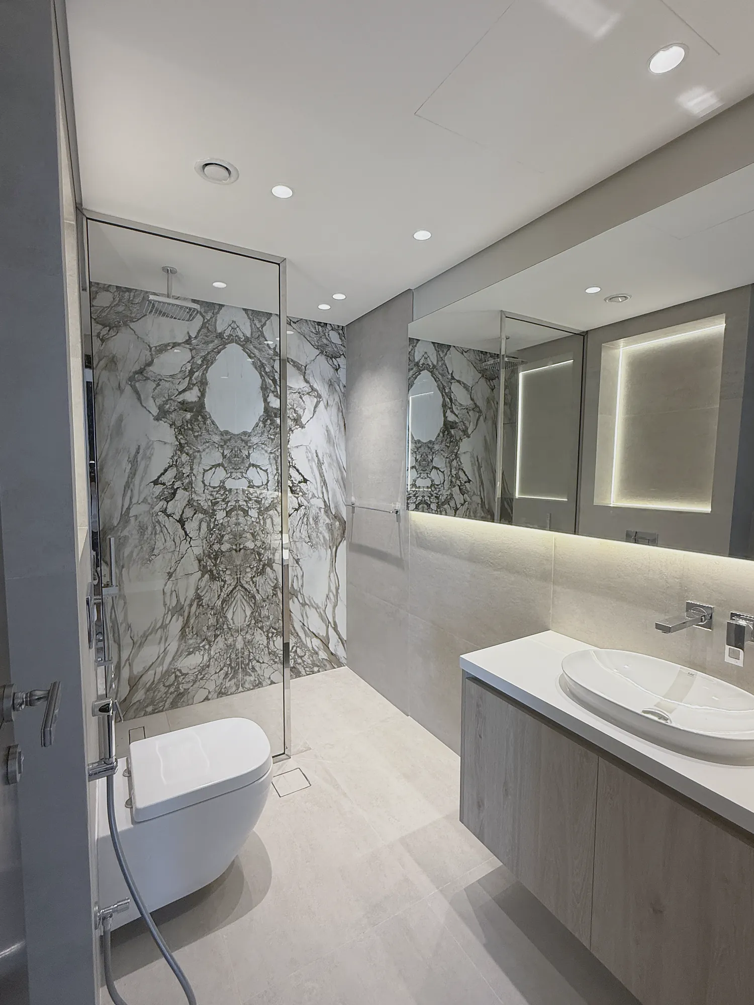 Marina Apartment bathroom with bookmatched marble shower wall and oak vanity, residential fit-out in Dubai