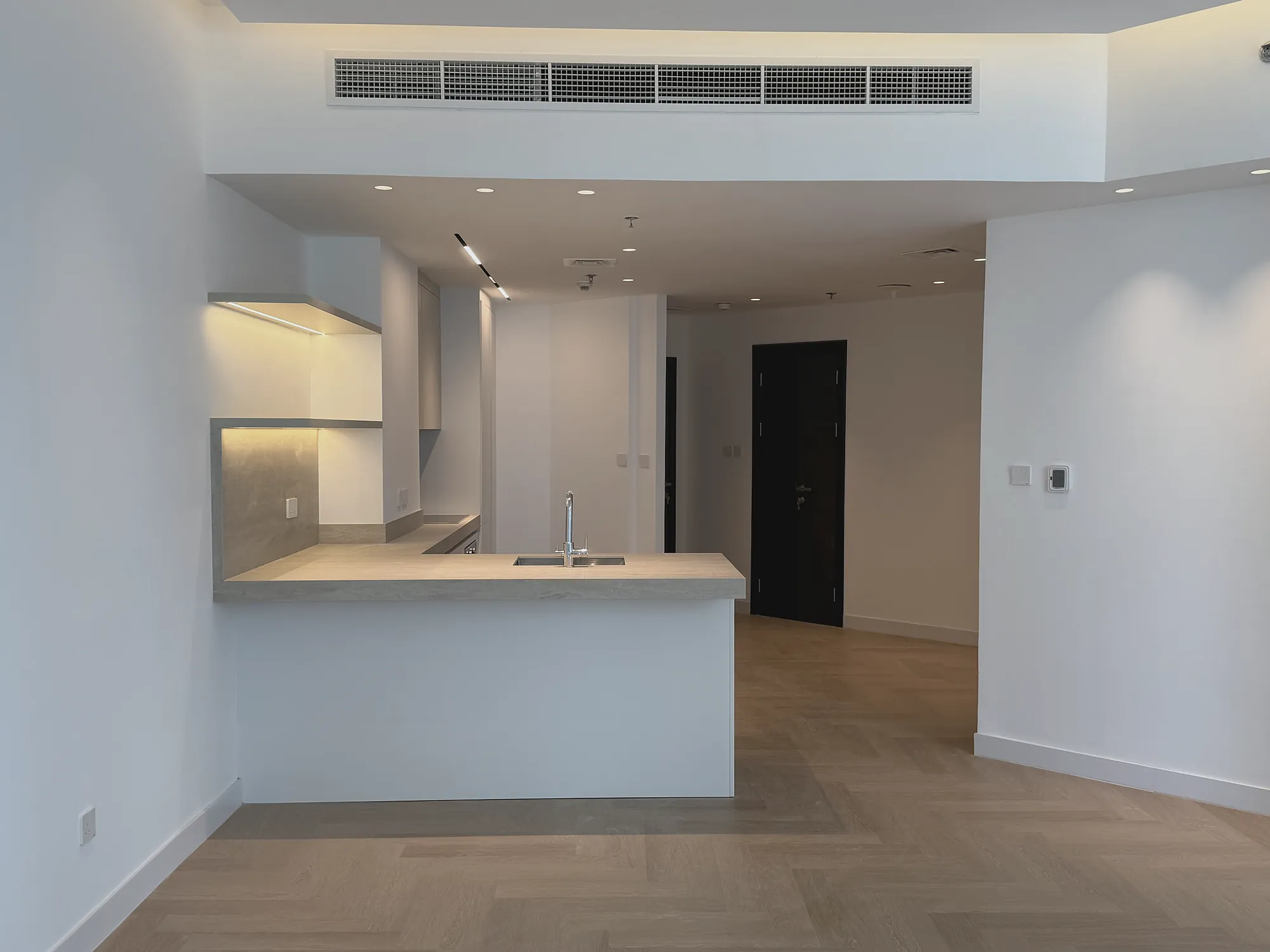 Marina Apartment open-plan kitchen peninsula and herringbone floor, residential fit-out in Dubai