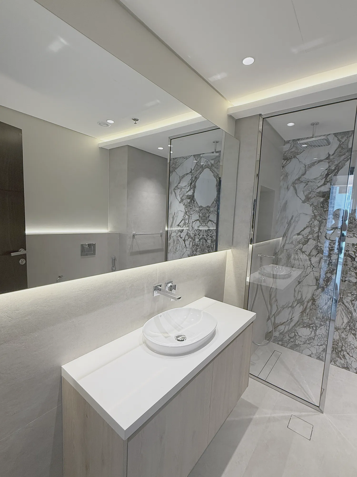 Marina Apartment vanity with vessel basin, backlit mirror and glass shower screen