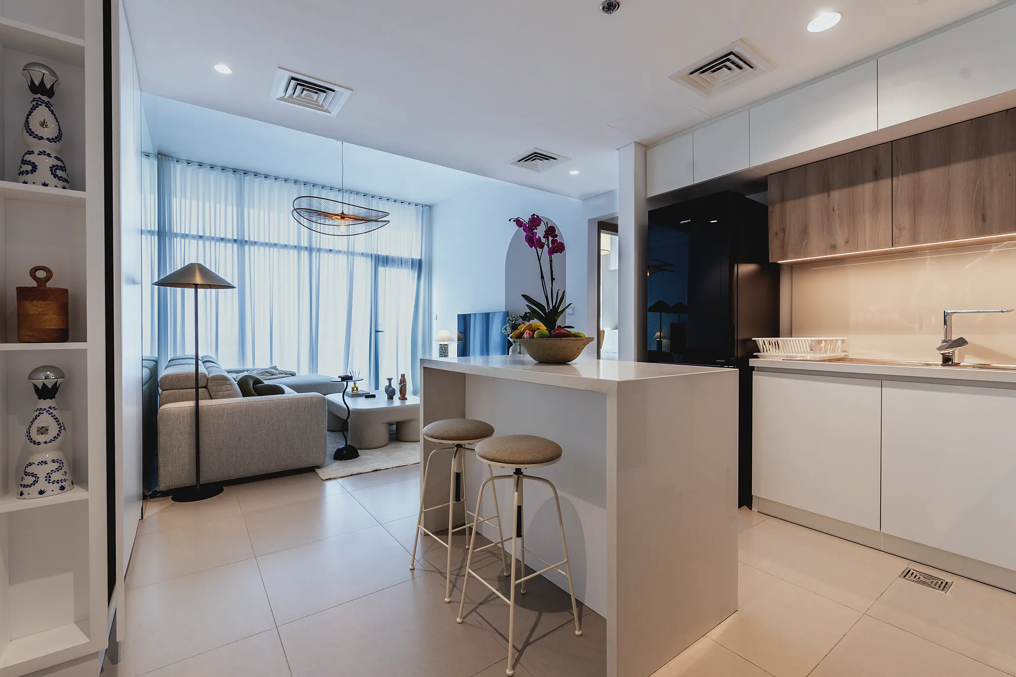 Prive 702 open kitchen with white island, oak wall units and bar stools